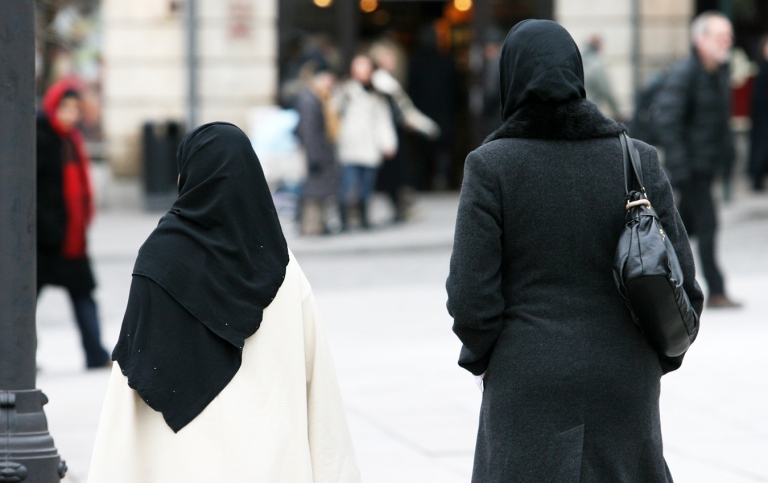 Two female muslims walking down the street.