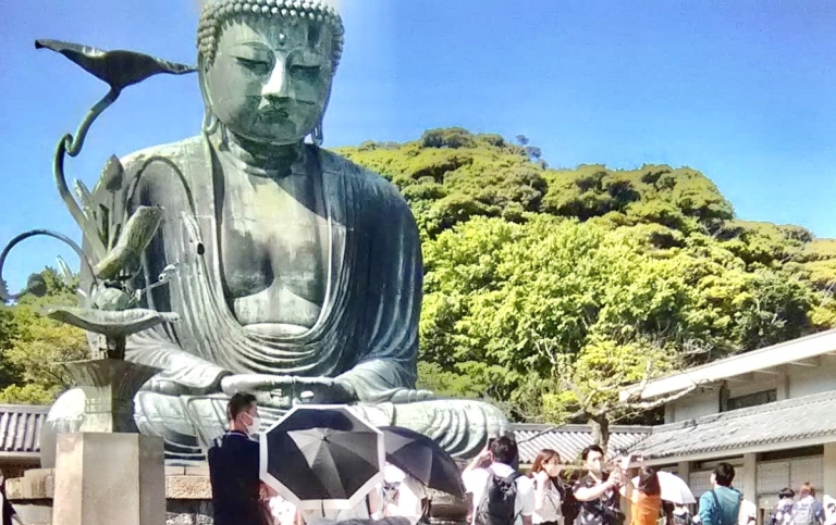Gwendolyne Knight framför en Buddhastaty i Japan. 