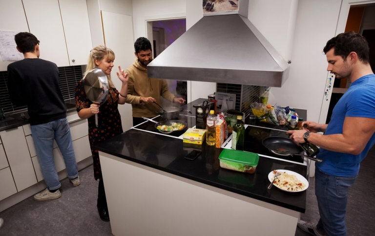 Students cooking in a communal student corridor kitchen.