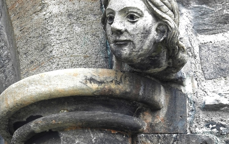 Bild på medeltida pelare med ansiktsdetalj