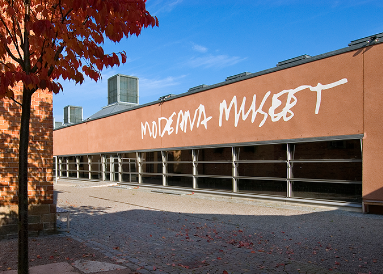 Utsidan av Moderna museet, en låg byggnad i brun puts