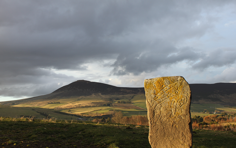 The Craw Stane Symbol Stone (foreground) and Tap o’Noth hillfort