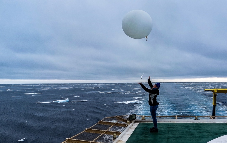 Forskare släpper sonderingsballong i luften från fartyg. Foto: Michael Tjernström