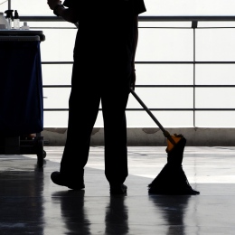 Silhouette of person sweeping floor