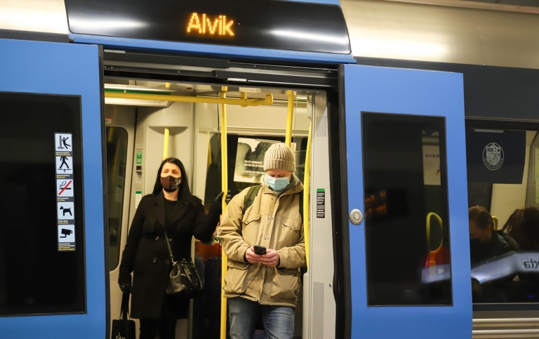 Två pendlare med munskydd i Stockholms tunnelbana. 