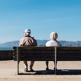 Två äldre personer sitter på en bänk