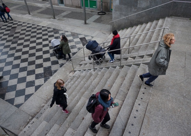People walking in different directions in a staircase.