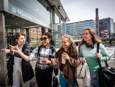 A group of young people walking down a sidewalk.