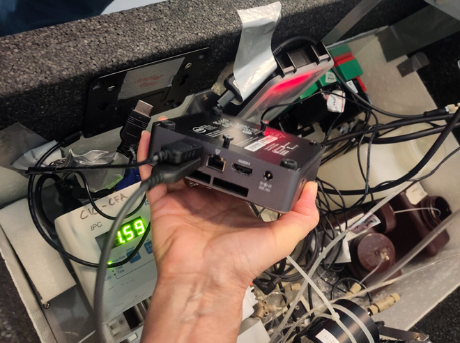 Close-up of a human hand holding a compact docking station box