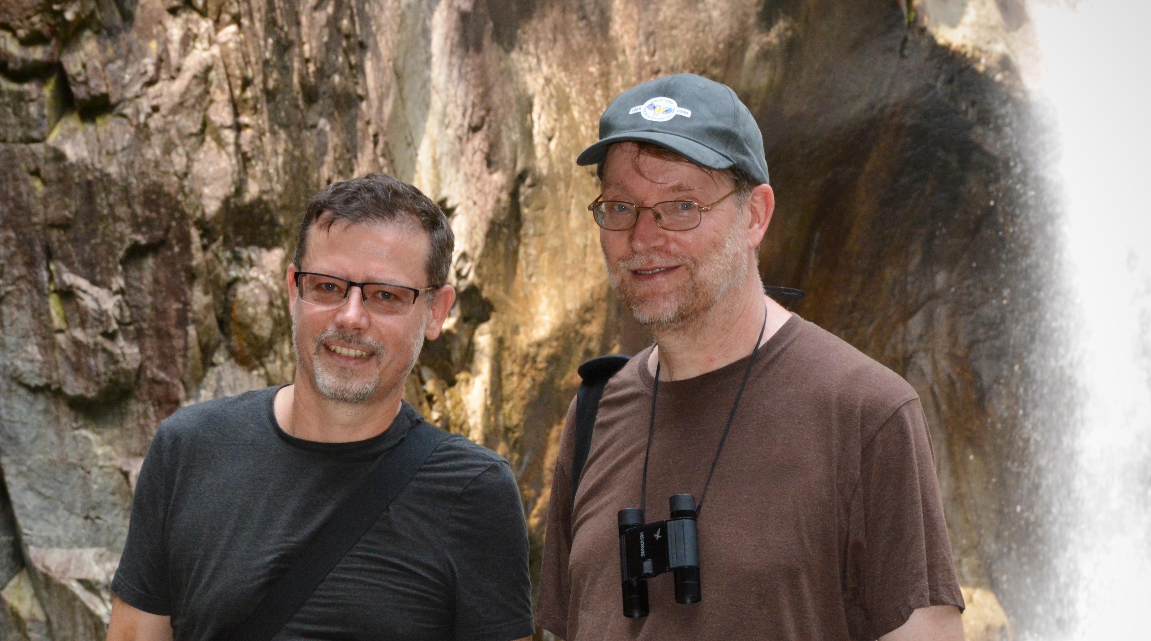 The two authors standing in front of a waterfall