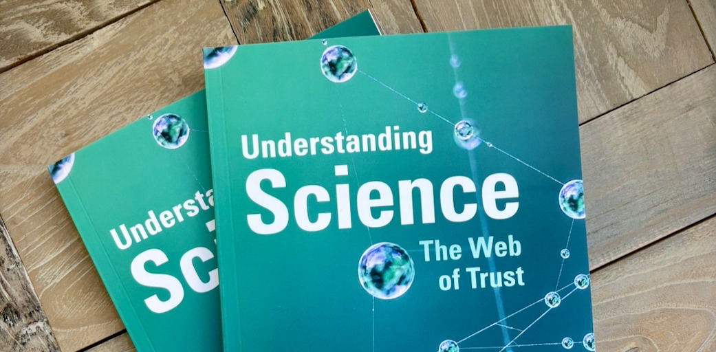 Two copies of the book on a wooden floor,