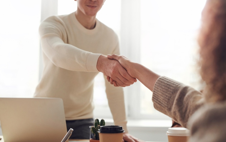 Handshake across a table.
