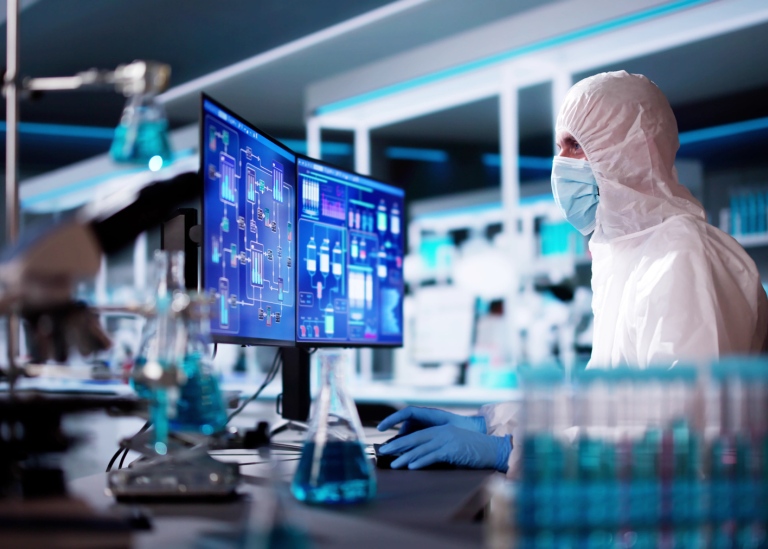 Person i labb-kläder sitter på ett modernt laboratorium