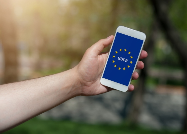 Person som håller upp en mobil där det står gdpr på skärmen