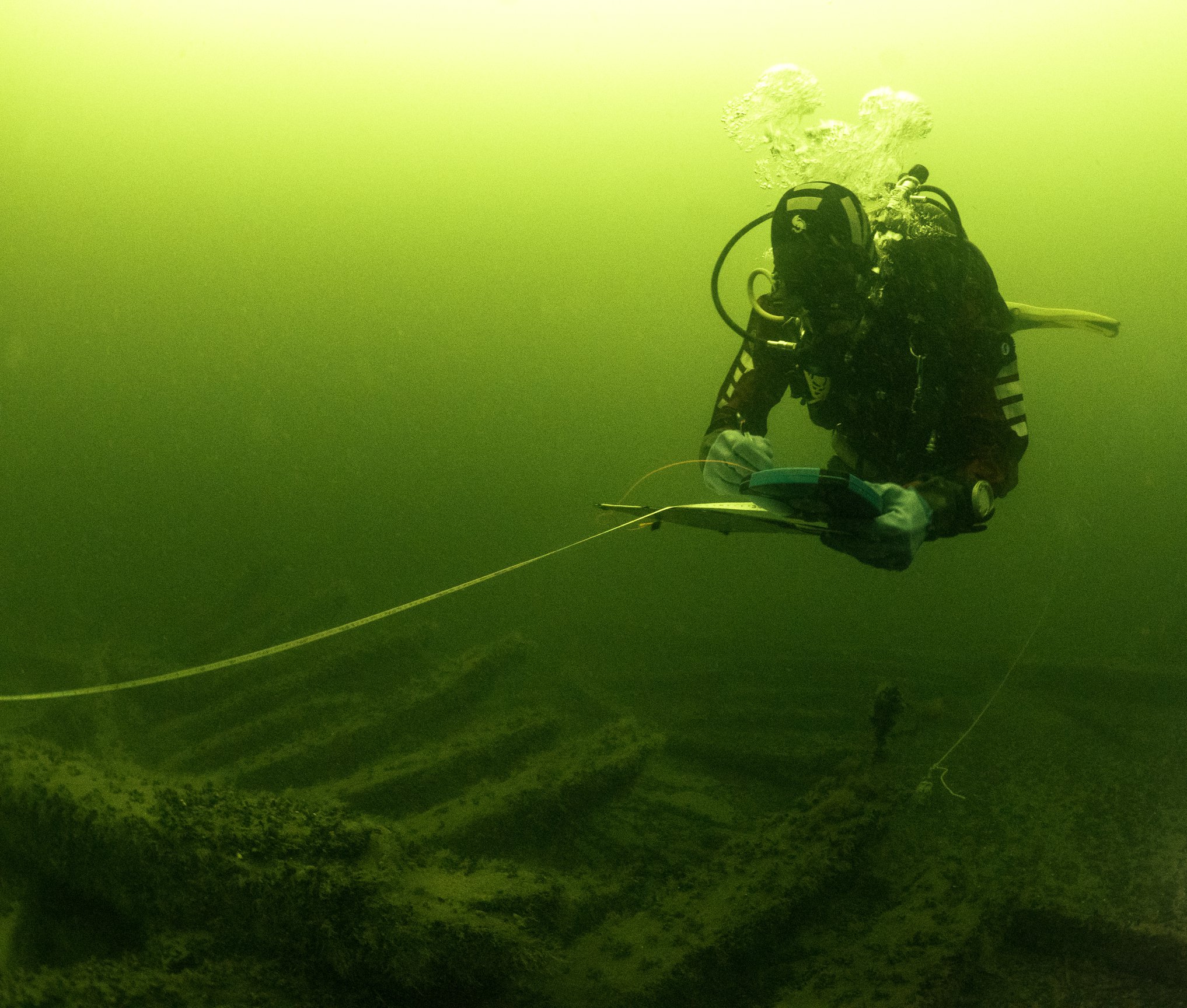 Niklas Eriksson sketches a shipwreck under water.