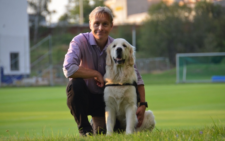 Dog and man on a soccer field.