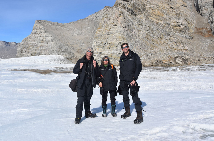 three people standing on Antarctica, looking at the camera.