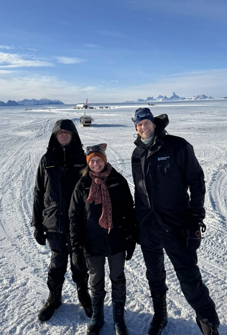 three people standing on Antarctica, looking at the camera.