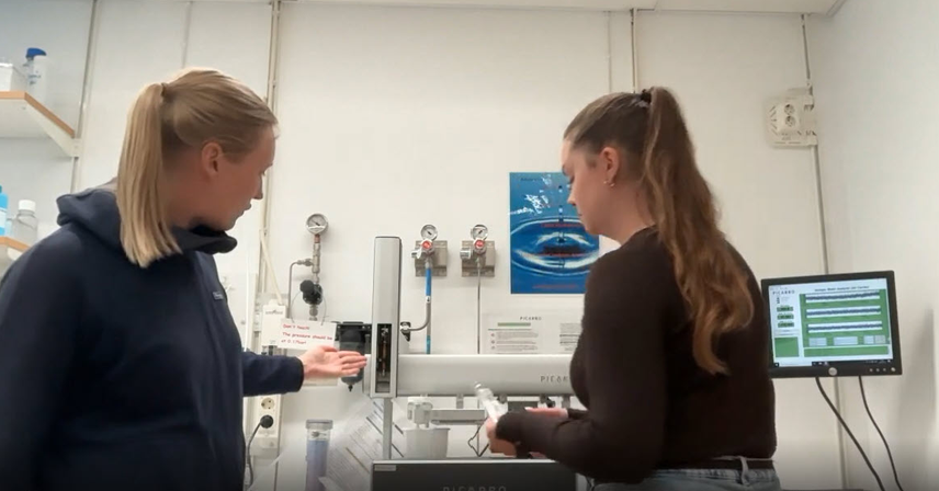 two researchers looking at some analysis equipment