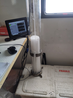 Ice core sample being analyzed on-site with a portable laboratory system called LISA, connected to a display screen