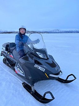 man sitting on snowmobile
