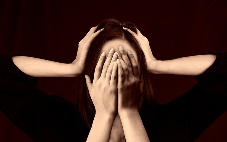 A woman with her hands in from of her face and two extra arms on top of her head.