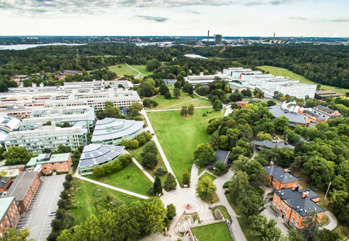 En del av campus Frescati från väster, ovanför tunnelbaneutgången (grönt tak i nedre bildkanten). Geovetenskapens hus är den gröna byggnaden till vänster och inkluderar de två tårtbitsformade husen.