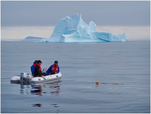 people on a rubber boat infront of an iceberg, Greenland.