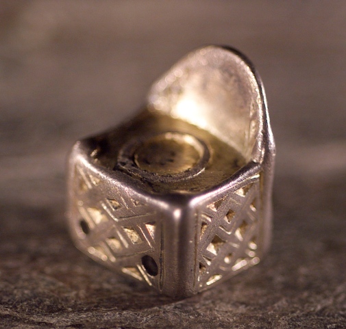 Stolsformat silverhänge från Eketorpsskatten (1,9x1,6 cm). Foto: Per Torgén, Örebro länsmuseum. Stolsformat silverhänge från Eketorpsskatten (1,9x1,6 cm). Foto: Per Torgén, Örebro länsmuseum