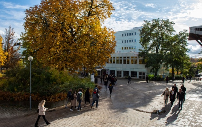 Människor utanför Södra huset en solig höstdag.