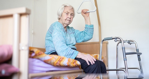 Äldrevård. 96 årig kvinna sitter på säng.