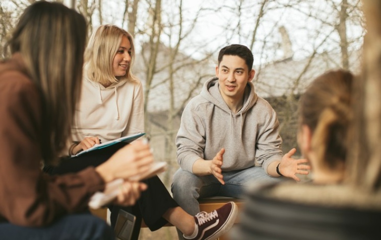 Studenter sitter och diskuterar.