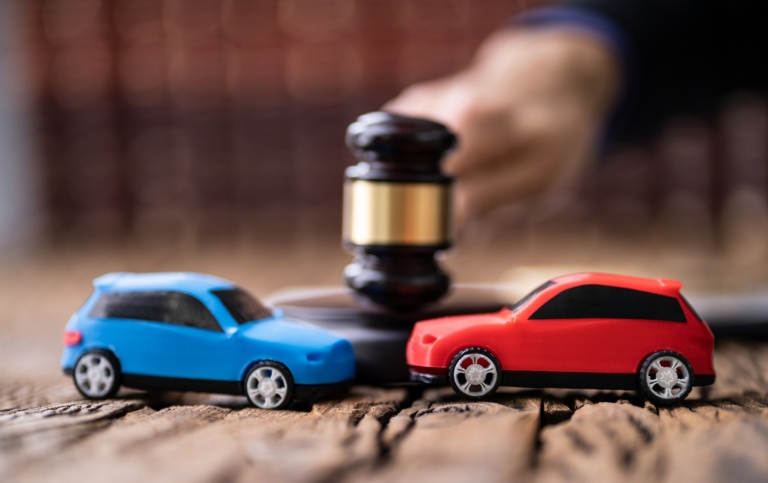 Two Cars In Front Of Gavel And Mallet And Judge Striking The Mallet