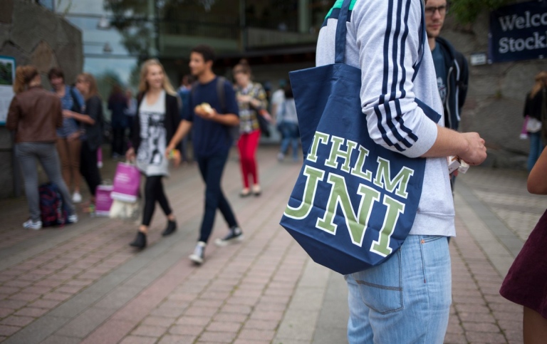 Student at Stockholm University on the background. Photo: Stockholm University