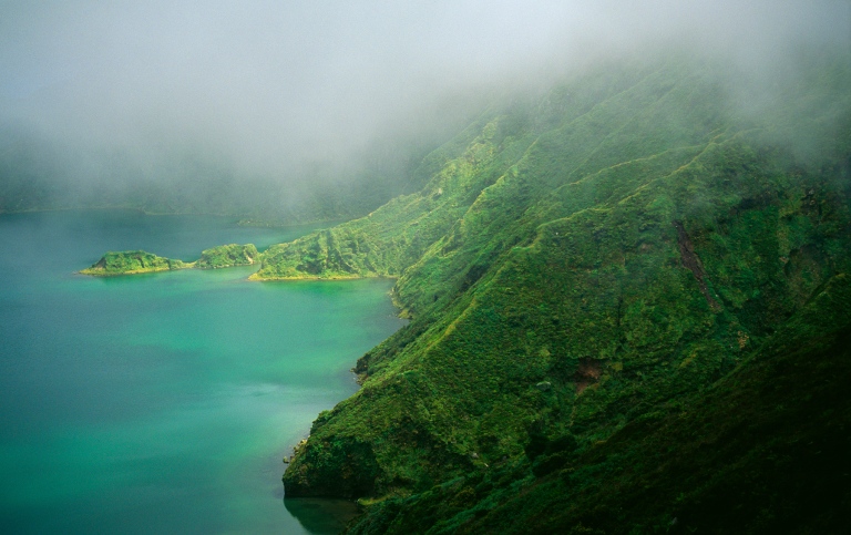 Green mountains on the right and a green lagon on the left side. Photo: Martin Jakobsson