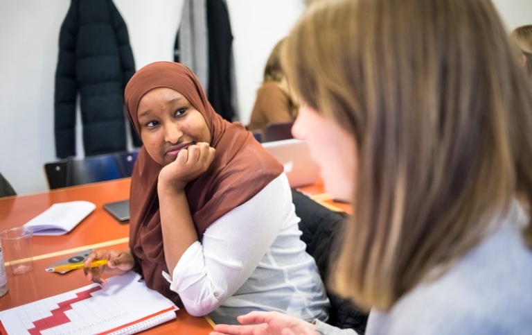 Två kvinnliga studenter samtalar. Den ena bär hijab, den andra inte. Foto: Niklas Björling