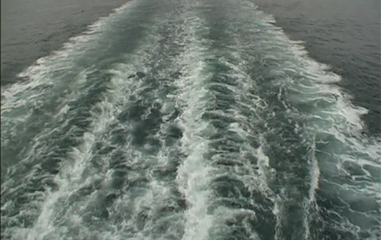 View over waves from a cruising ship.