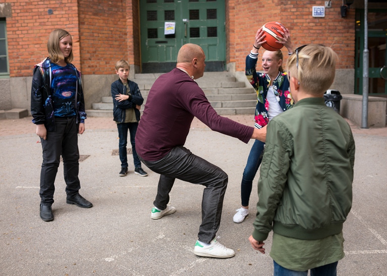 Lärare leker boll med elever på skolgård. Foto: Katja Kircher/Mostphotos