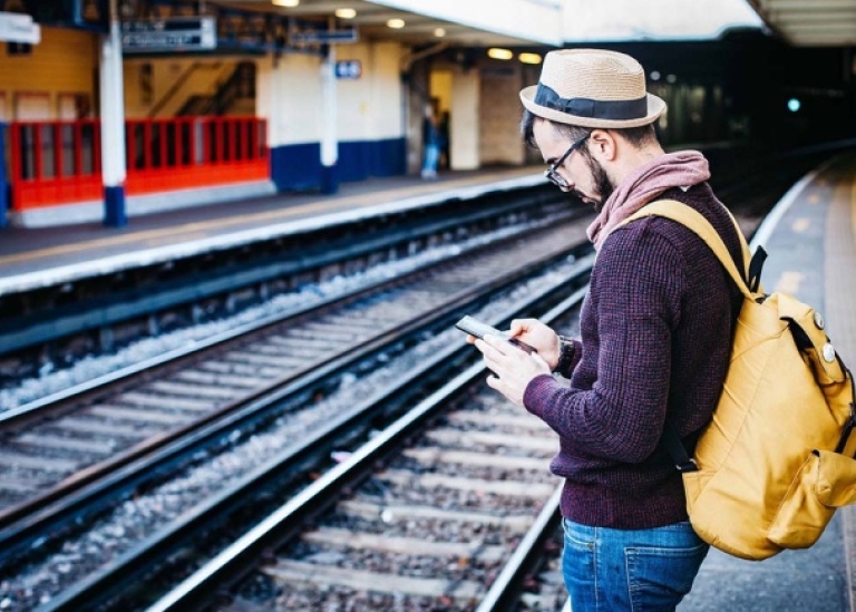 Man standing on a railway station. Unsplash