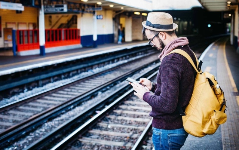 Man standing at railway station. Photo: Clem Onojeghuo/Unsplash