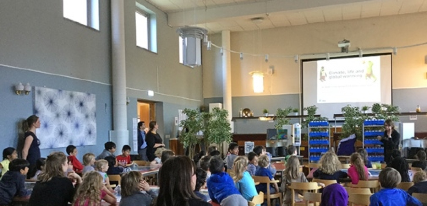 en skolsal med elever som tittar framåt på en filmduk