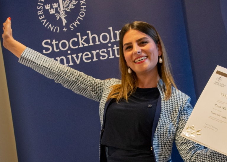 Kvinnlig student med diplom på magisterpromotion i aula magna. Foto: Ingmarie Andersson