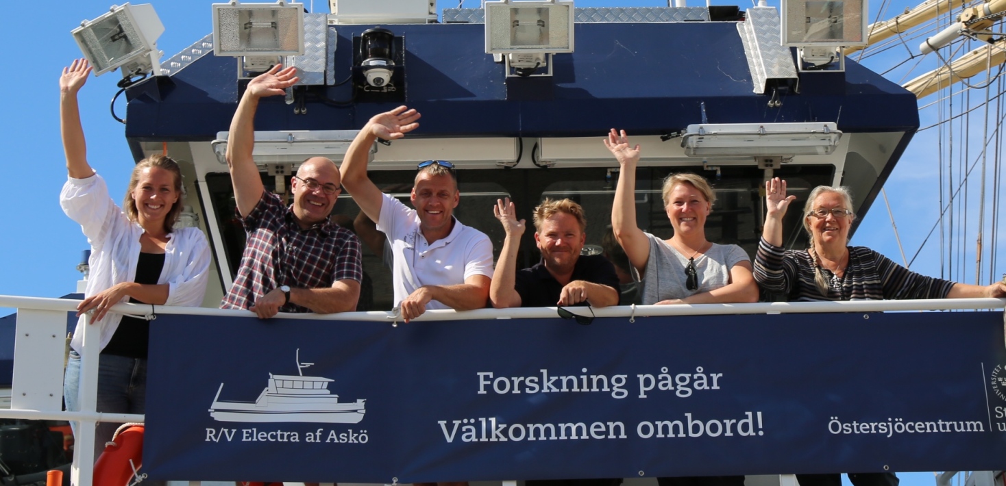 Flera medarbetare från Östersjöcentrum står på fartyget Electra och vinkar till kameran.