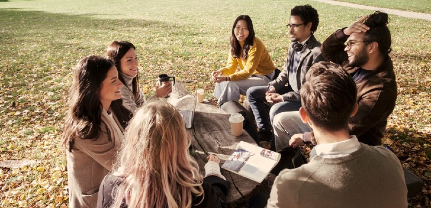 Studenter i grupp som sitter ute vid bord och samtalar. Foto: Jens Olof Lasthein/Stockholms universi