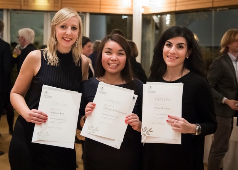 Three female students in Aula Magna, with their master degree certificate diplomas. Photo: Niklas B