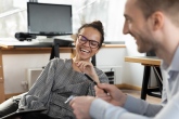 Kvinna på kontor skrattar så hon kiknar, manlig kollega o profil skrattar. Foto: Aleksandr Davydov