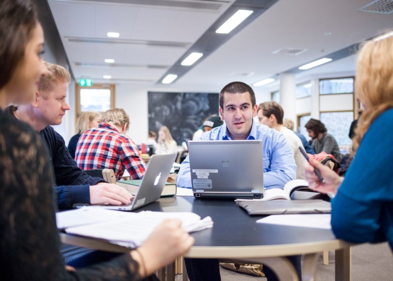 Four students sitting around a table in the library