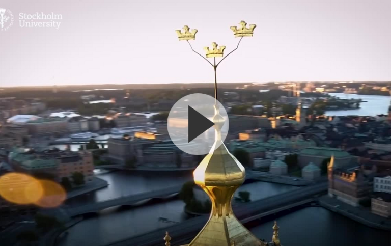 Still from video of Stockholm from above. Stockholm City Hall's tower crowns close to the camera