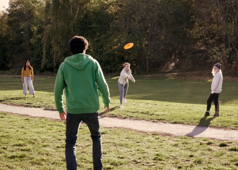 Fyra personer kastar frisbee.