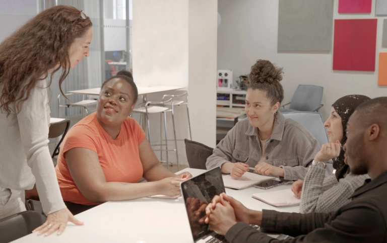 Group of adults talking in a classroom.